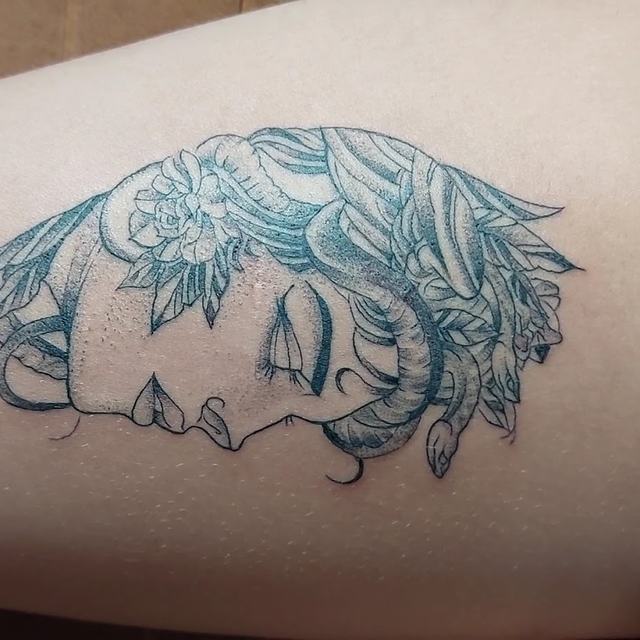 Portrait line-art tattoo on a thigh